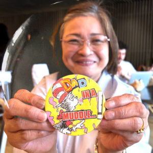A smiling participant showing off her badge