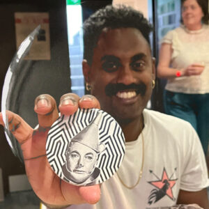 A smiling participant showing off a badge