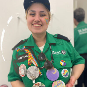 A smiling St John Ambulance officer in a uniform covered in badges