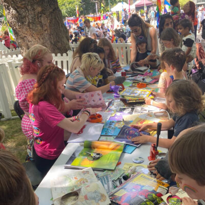 Josa hosting an open-air badge table with more than a dozen young people