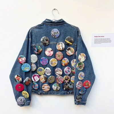 A denim jacket covered in badges made as part of METRO Charity's exhibition marking their 40th anniversary