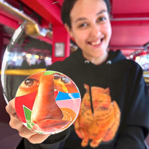 Smiling participant showing off a collage badge at Rich Mix