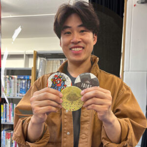 A smiling participant at Charing Cross Library showing off his badges