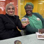 Two smiling participants at Rampayne St Community Hub showing off their badges
